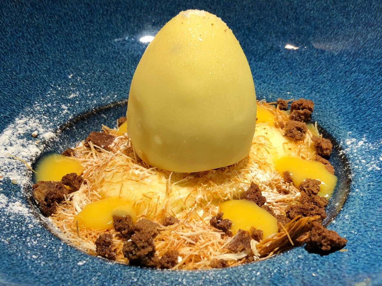 Huevo de chocolate blanco sobre arroz con leche y relleno de sorbete de piña